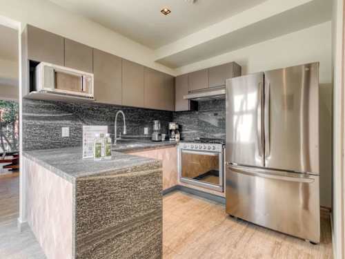 Fully equipped kitchen with stainless steel fridge and modern finishes, everything you need to cook a proper meal in