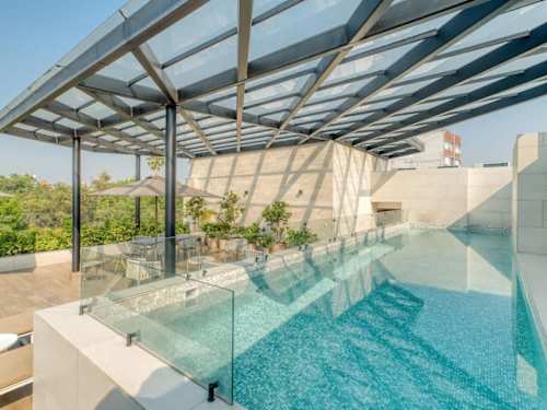 Rooftop pool under a sculptural pergola, a cool dip with treetop views over Condesa