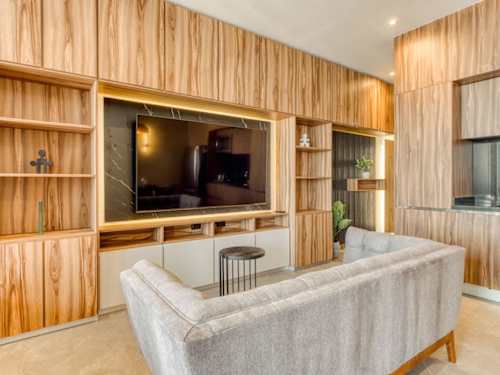 Sleek living space with a smart TV and soft sofa in warm wood tones, easy downtime on Reforma