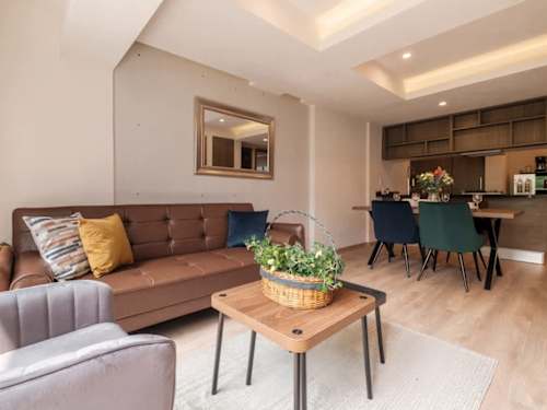 Open living and dining area with a leather sofa and warm wood table, relaxed, stylish living steps from Paseo de la Reforma