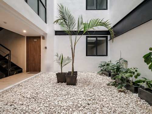 Light-filled interior courtyard with planters and river-stone detailing, a tranquil, green welcome home