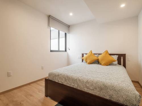 Serene bedroom with soft linens and cheerful pillows, a calm retreat a short walk from El Angel