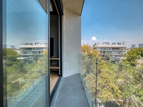 Private balcony with a glass railing and leafy city views, a breezy corner for morning coffee or an evening drink