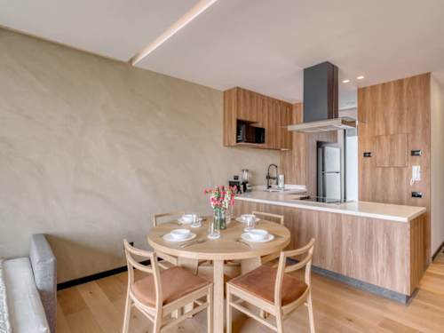 Warm dining nook with a round table by the open kitchen, an inviting spot for coffee or a home-cooked meal
