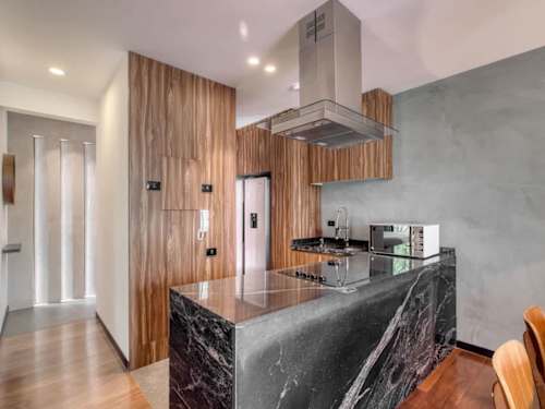 Sleek kitchen with a marble island and statement range hood, a stylish, fully equipped space to cook and gather