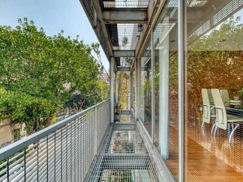 Leafy top-floor balcony walkway with seating, sip your coffee among the treetops of Roma Norte