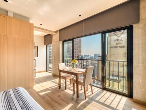 Relaxed dining and living corner bathed in daylight, gather easily just off the balcony