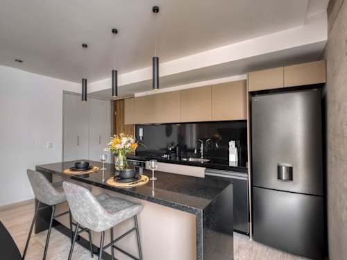 Sleek island kitchen with breakfast bar and full-size fridge, pull up a stool and cook in style