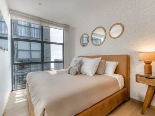Restful king bedroom with round mirrors and warm wood, soft light for a great night's sleep