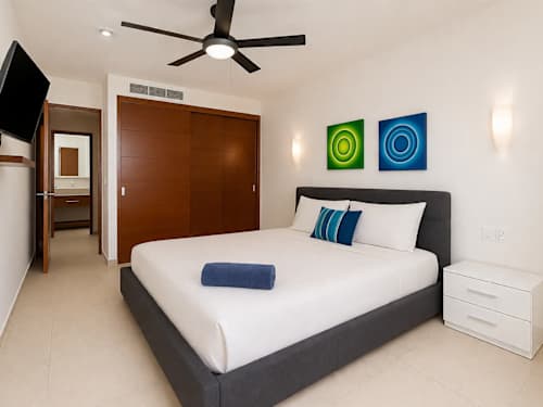 Bedroom with queen bed, smart TV and ceiling fan