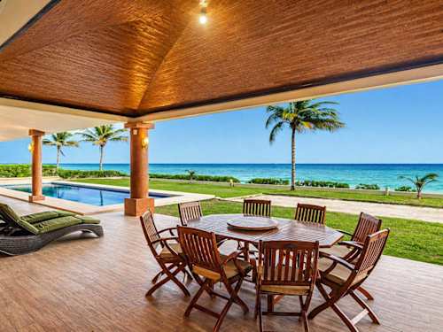 Covered oceanfront patio with outdoor dining