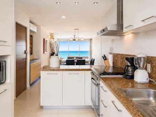 Fully equipped kitchen with stainless appliances and granite counters, cook in with a sea view in sight