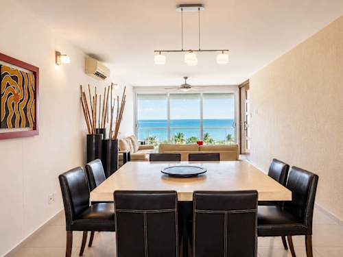 Elegant dining area for the whole group with bright ocean-view windows, gather over unforgettable meals