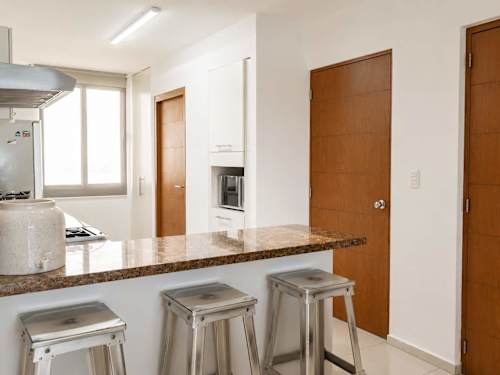 Sleek kitchen with a granite breakfast bar and stools, a casual spot for coffee and quick bites
