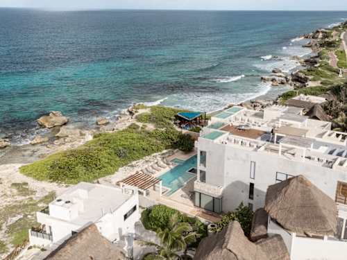 Aerial view of the oceanfront Yaxché complex and rocky Caribbean shoreline