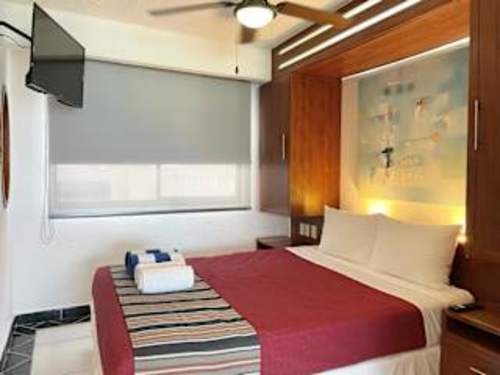 Bright bedroom with a comfy bed, TV and rich wood details, an inviting place to recharge