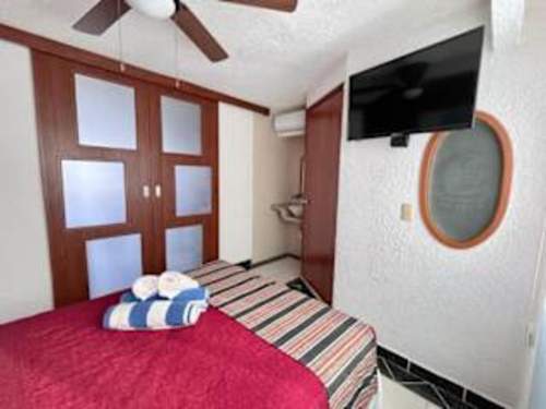 Cozy bedroom with a comfy bed, TV and warm wood accents, a restful retreat after a day at the beach