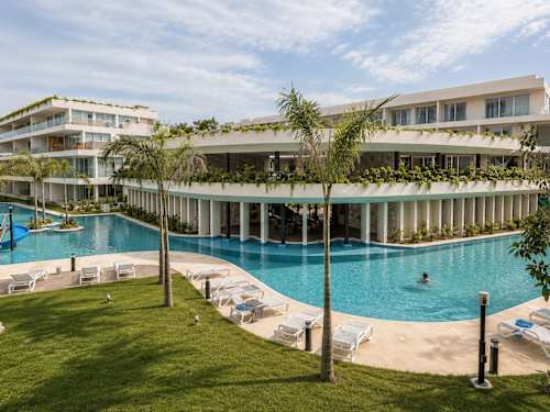 Resort-style shared pool surrounded by tropical gardens