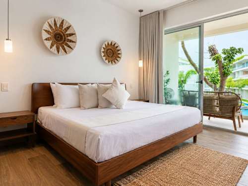 Private balcony with rattan seating and pool/garden views