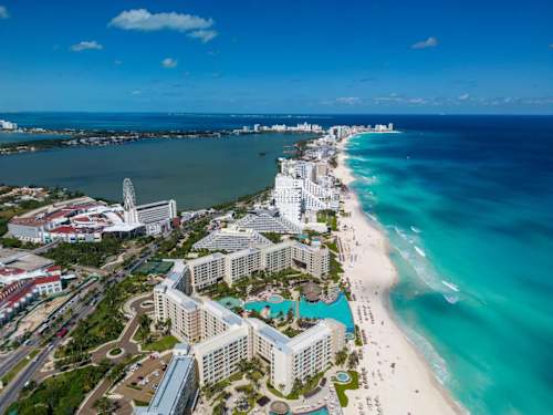 Sweeping aerial view of the Cancun Hotel Zone, turquoise sea and white-sand beach moments away