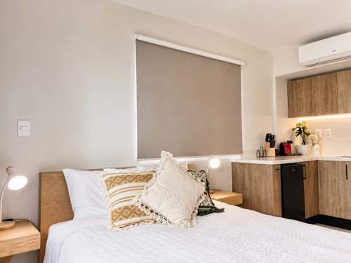 Cozy studio bedroom with soft linens and a handy workspace, comfortable for both rest and remote days