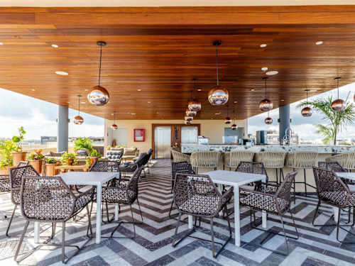 Rooftop lounge and dining area under a warm wood ceiling, an inviting spot to gather over meals just steps from Fifth Avenue in Playa del Carmen