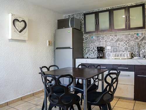 Handy kitchenette and dining table with cheerful tilework, ready for easy home-cooked meals