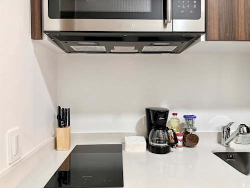 Modern kitchenette with stovetop, coffee maker and the essentials for easy meals