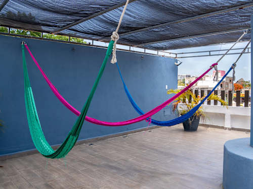 Colorful hammocks swaying on the shaded rooftop, the perfect place to nap away a warm afternoon