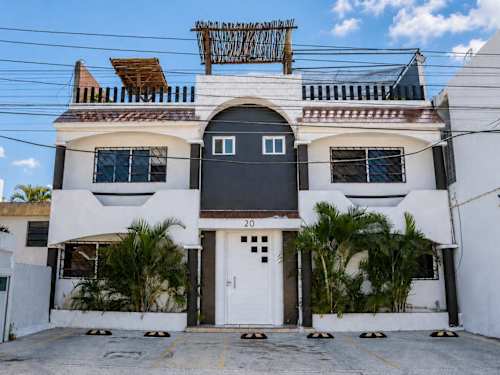 Welcoming facade of the Coco 20 building framed by tropical greenery in central Cancun