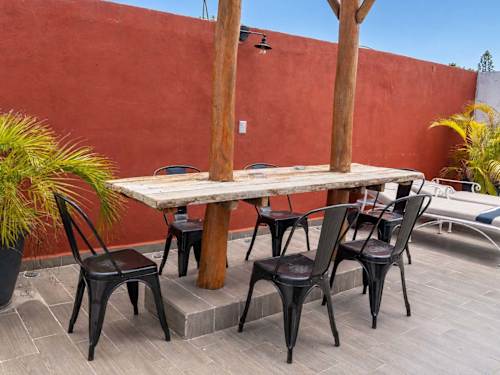 Shared rooftop terrace with a long dining table for group meals and open-air evenings in the heart of downtown Cancun
