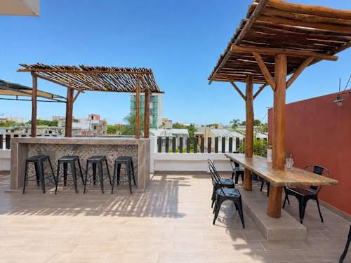 Breezy rooftop bar and seating under the pergola, a relaxed social hub above the streets of downtown Cancun