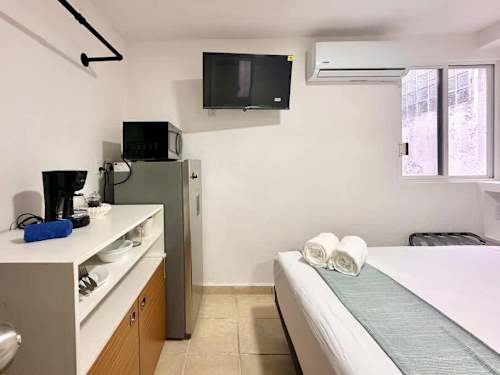 Smart studio setup with a kitchenette, TV and cozy bed, easy everyday living in central Cancun