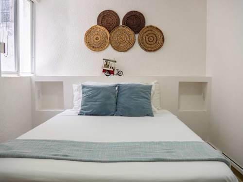 Restful bedroom with a comfy double bed, fresh linens and warm woven decor for a great night's sleep