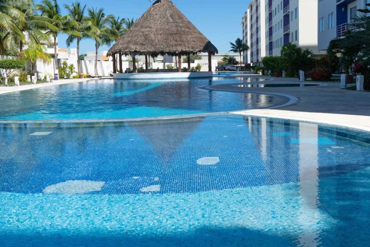 Shared outdoor pool with shaded palapas