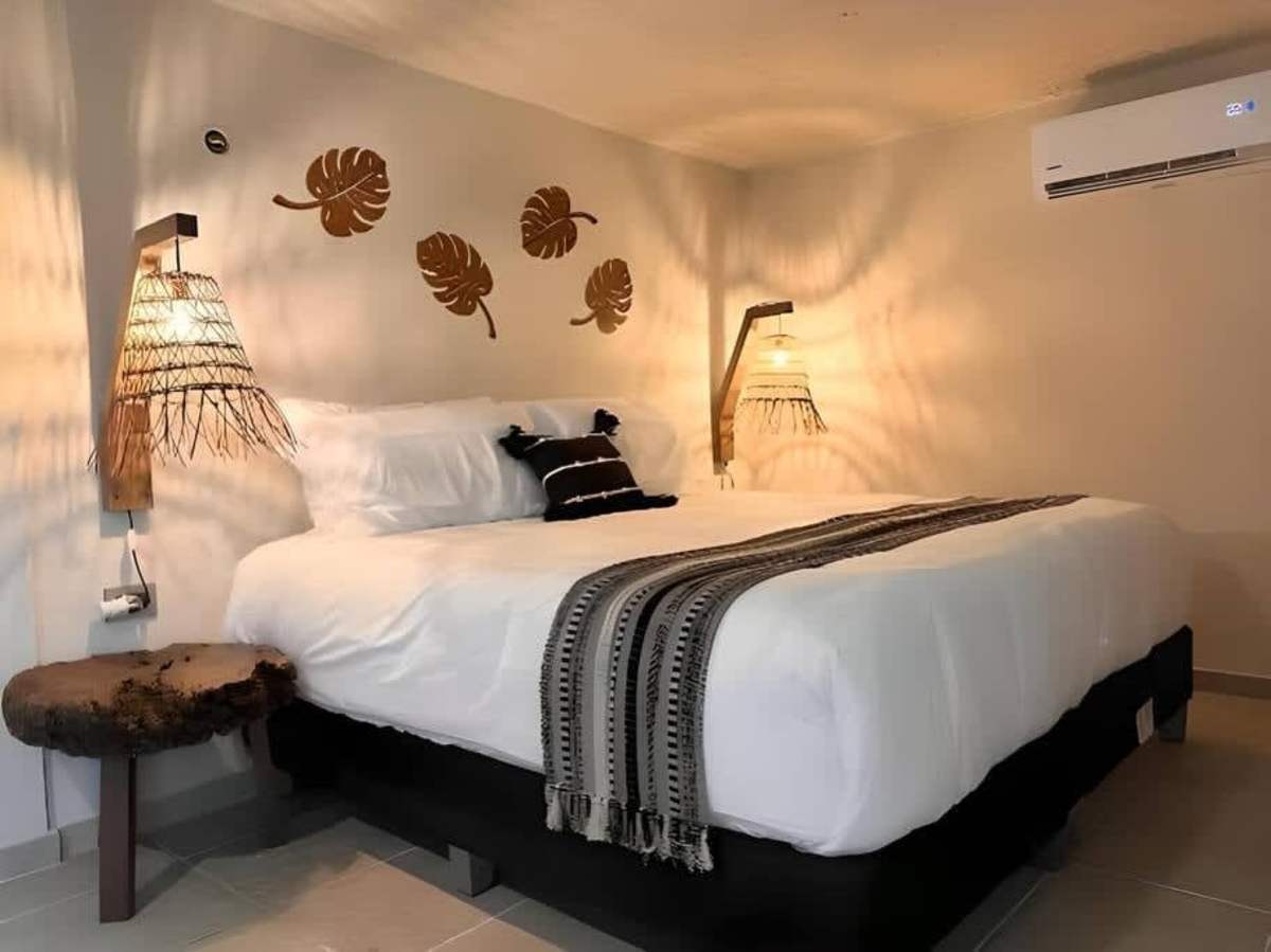 Studio sleeping area with king bed and decorative wall
