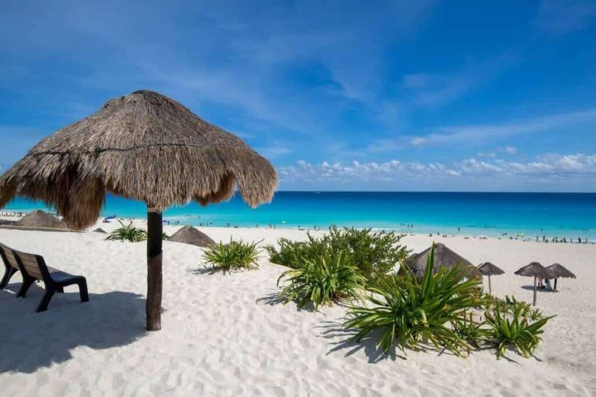 Powder-white beach dotted with palapas beside the turquoise Caribbean, your patch of paradise in Cancun's Hotel Zone
