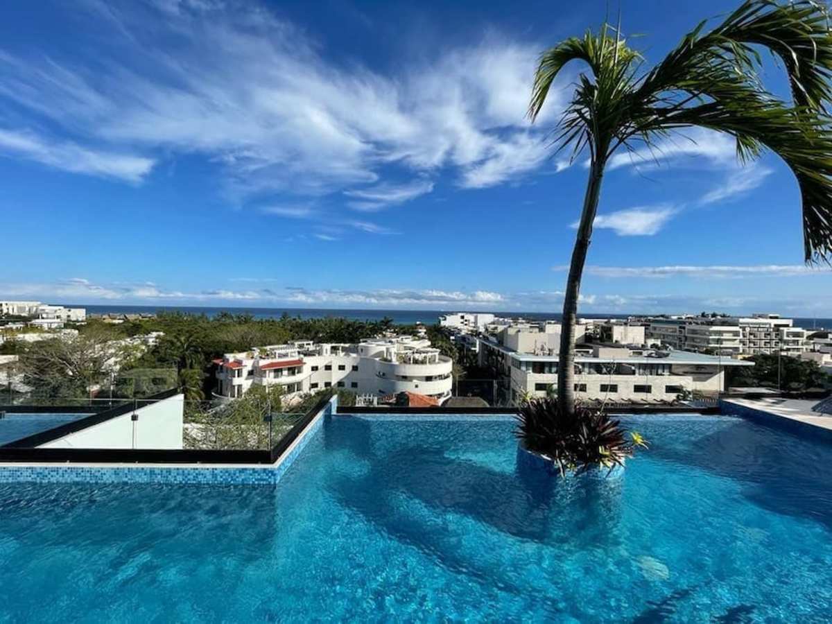 Shared rooftop pool with Caribbean ocean views and loungers