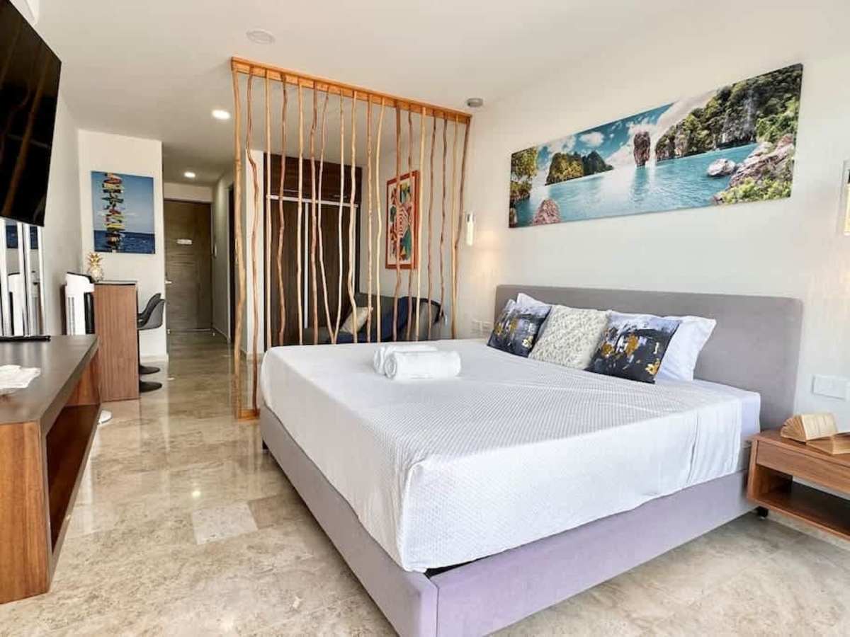 Serene bedroom with a king bed and elegant golden screen, your restful retreat in Playa del Carmen