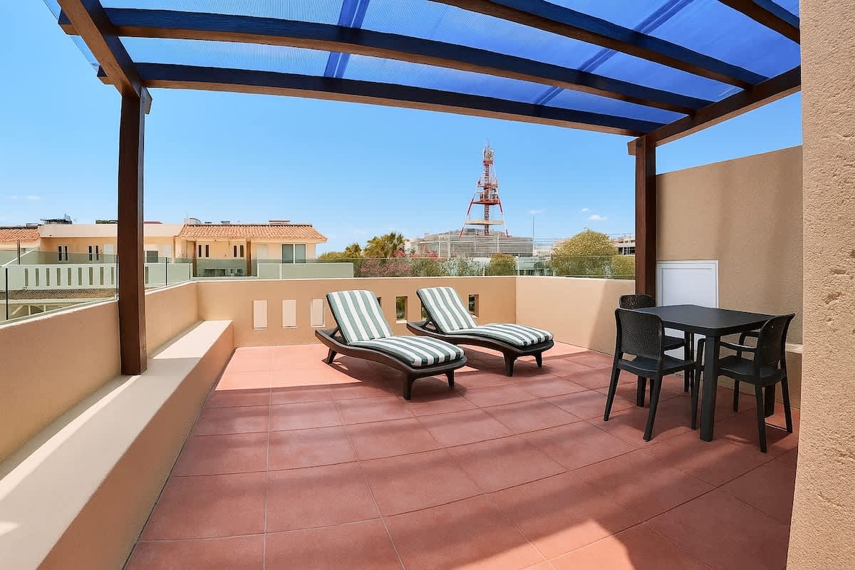 Private rooftop terrace with sun loungers and dining area.