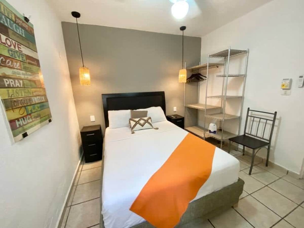 Restful bedroom with a comfy double bed and open shelving, a bright and calm base in downtown Cancun