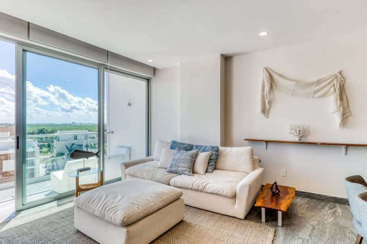 Open-plan living room with sofa and ocean views