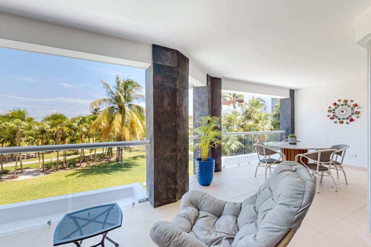 Living area opening to the balcony with garden and sea views
