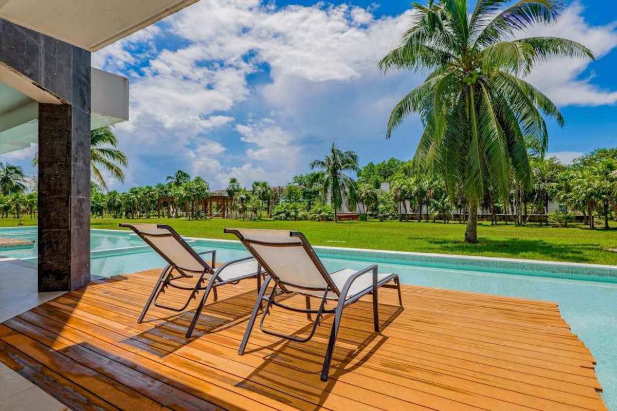 Private covered patio with seating and garden views