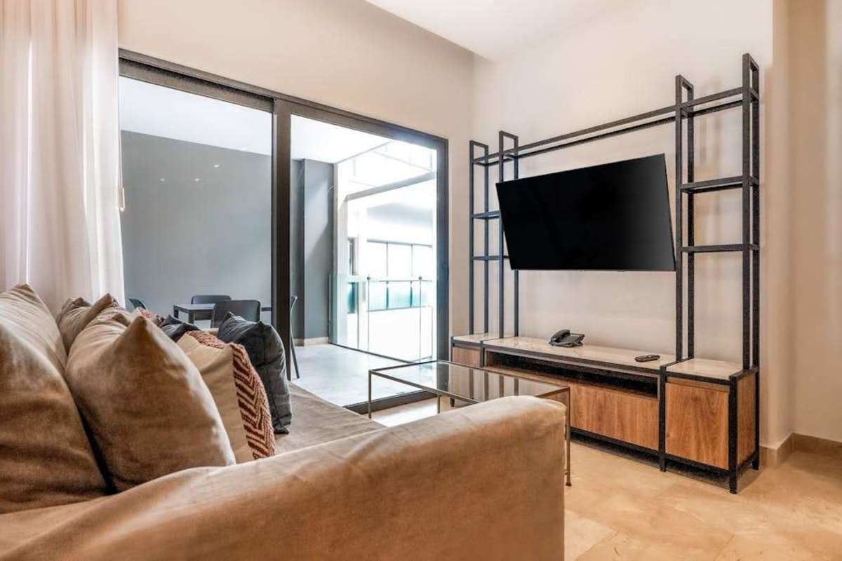 Living room with sofa, smart TV and balcony