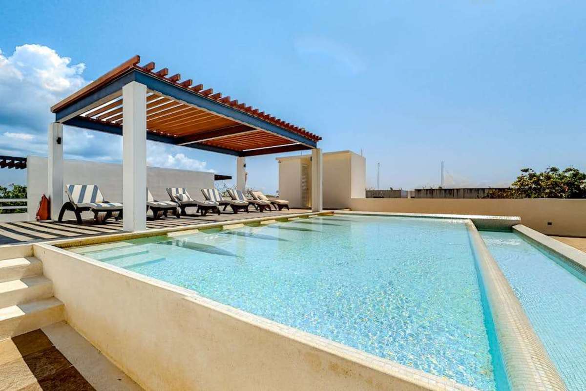 Shared rooftop pool with sun loungers