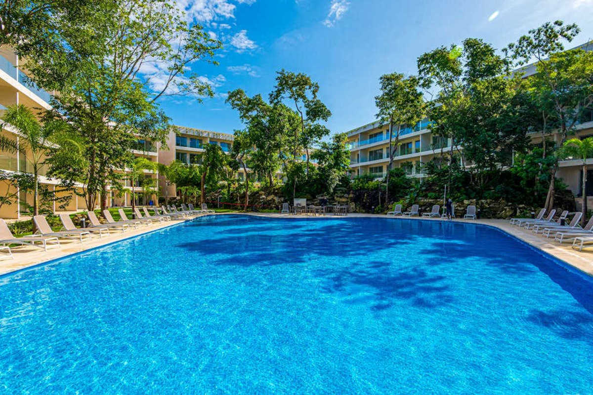 Sparkling resort pool wrapped in tropical greenery, your everyday escape near Fifth Avenue and the beach