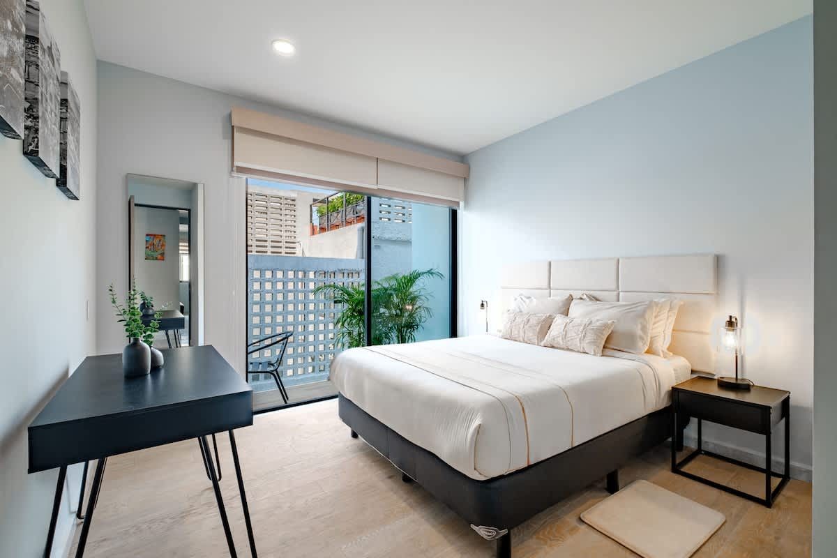Restful bedroom with a plush bed and leafy window light, an easy retreat in the heart of Roma Norte