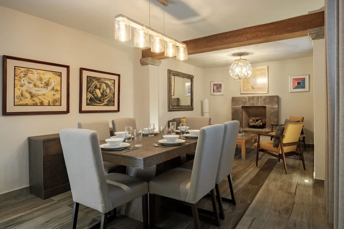 Warm dining area with framed art and rich wood floors, an inviting table for meals in the heart of San Miguel de Allende