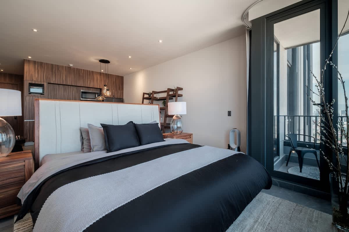 Restful bedroom with a plush king bed and floor-to-ceiling windows, an easy night's sleep high above Reforma